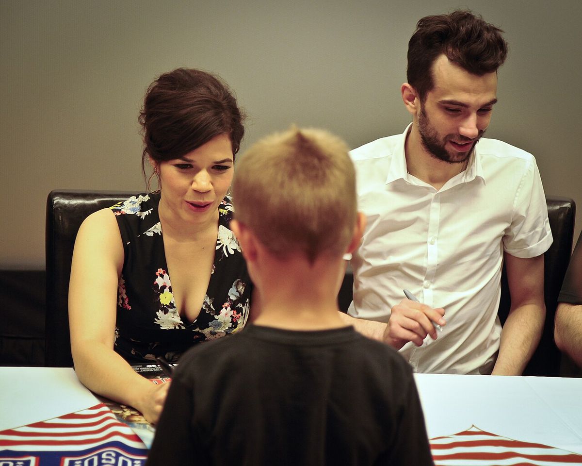 America Ferrara and Jay Baruchel, voices of characters in the new movie “How to Train Your Dragon 2”, sign autographs during a USO tour June