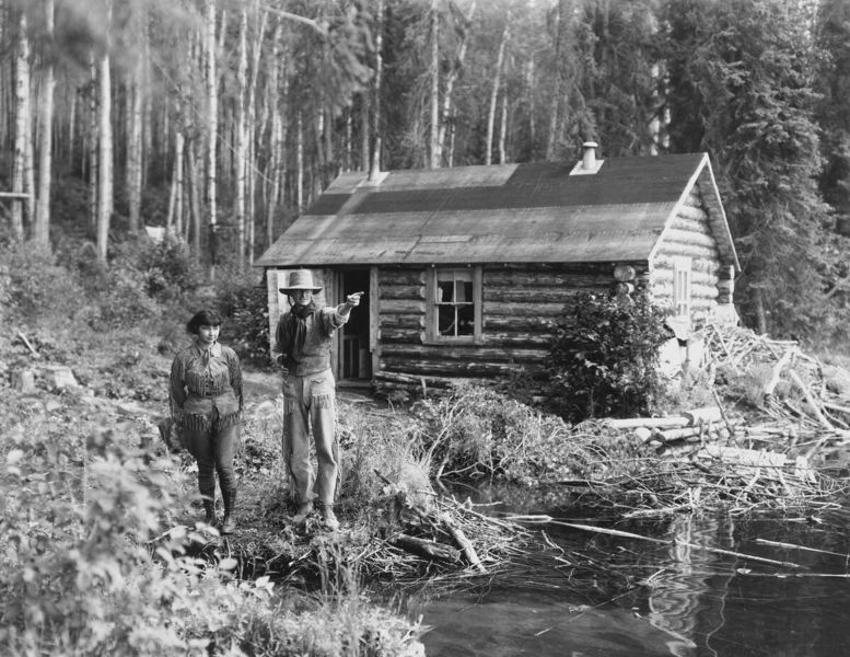 "Grey Owl and wife Anahareo at cabin, Lake Ajawaan, Saskatchewan.", [ca. 1933-1934], (CU1128747) by Oliver, W. J.. Courtesy of Glenbow Libra