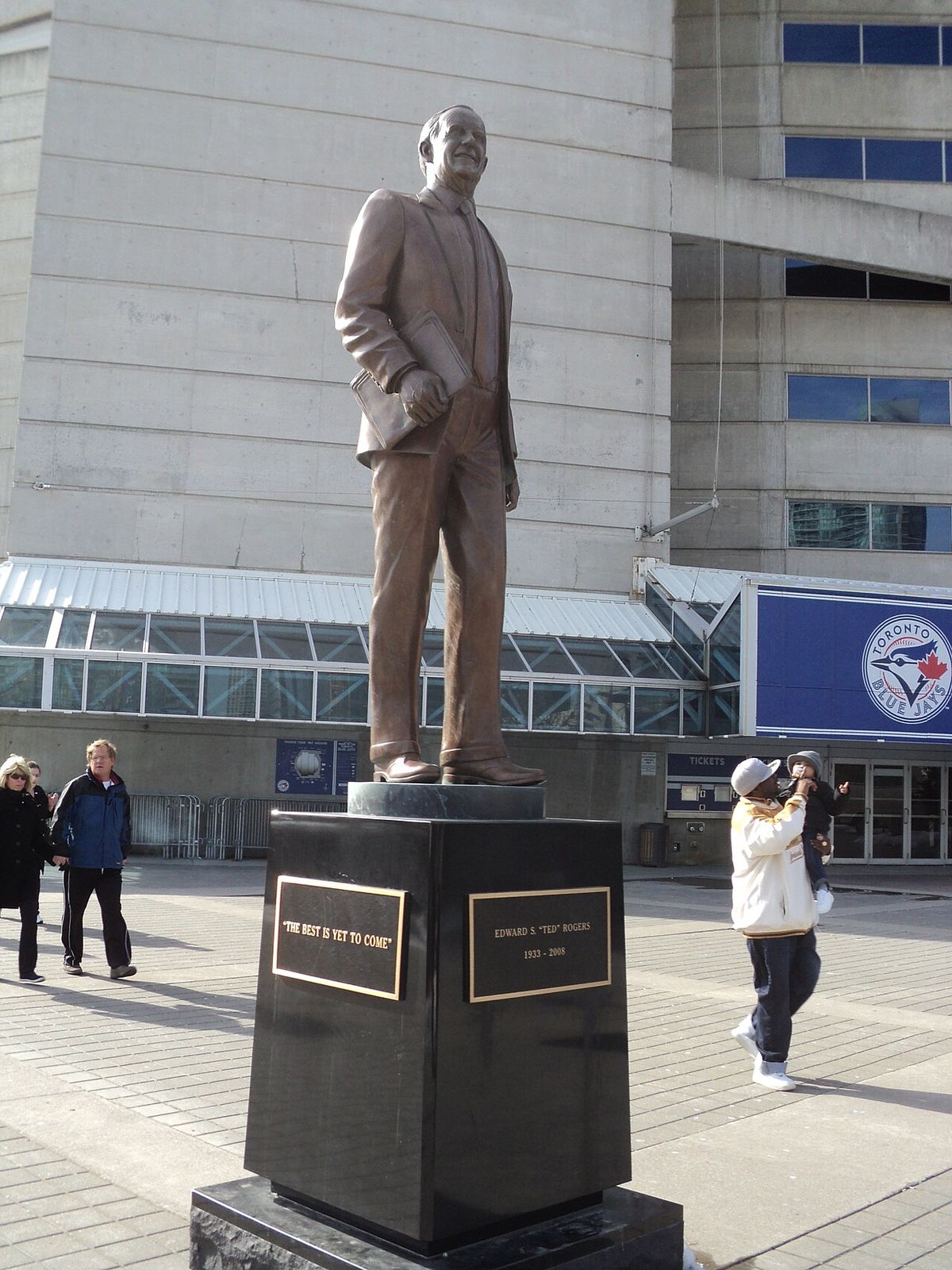 Statue of Ted Rogers in front of the Rogers Centre in Toronto. The plaque on the left reads "The best is yet to come".