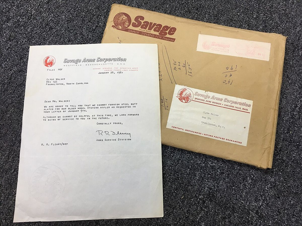 A typewritten letter from Savage Arms laid askew over a brown mailing envelope. The letter is dated 1961 and contains a response to a custom